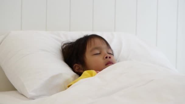 Linda Niña Está Durmiendo Una Cómoda Cama Blanca Manta Dormitorio — Vídeo de stock