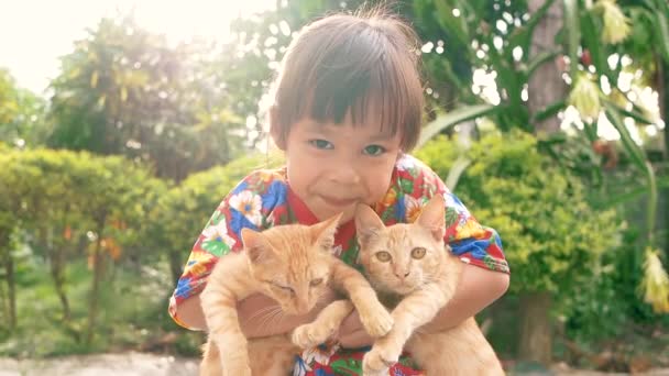 裏庭で子猫を2匹飼っている幸せな女の子 かわいいペットのコンセプト — ストック動画