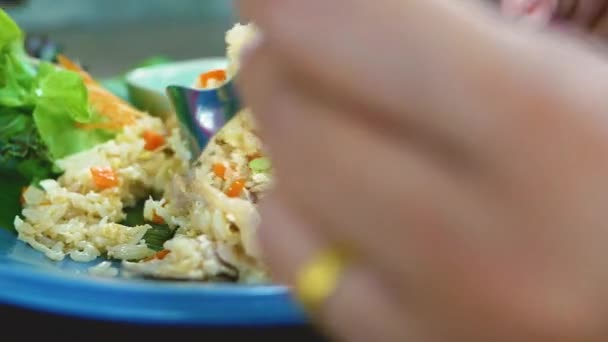 タイ料理を食べる女性レストランで野菜やソーセージを添えて豚肉炒めご飯 — ストック動画