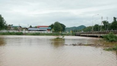23 Ağustos 2020: Yom Nehri gece boyunca yağan şiddetli yağmurlar nedeniyle daha yüksek su içermektedir. Phrae, Tayland 'daki sel baskınının video görüntüleri.
