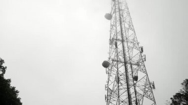 Telekomünikasyon kuleleri. Televizyon antenleri ve uydu anteni olan. Dağdaki sisli sabahta..