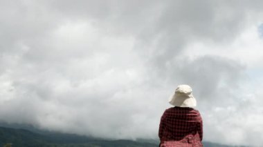 Başarıyı ifade eden kadın, elleri dağın zirvesinde, gökyüzü arka planında. Başarı ve kazanma kavramı.