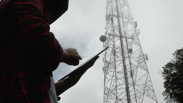 Kvinnlig Ingenjör Med Surfplatta Kontrollerar Frekvensen Med Telekommunikationstorn Med Antenner — Stockvideo