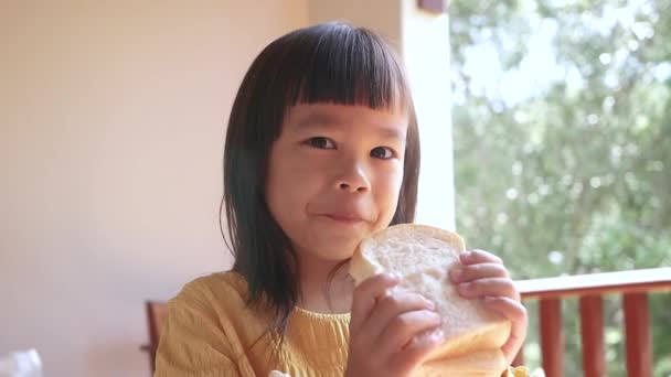 Liten Asiatisk Flicka Som Äter Bröd Morgonen Söt Liten Flicka — Stockvideo