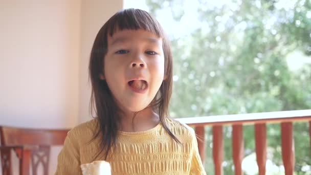 亚洲小女孩早上吃面包 可爱的小女孩在家里吃早餐 — 图库视频影像