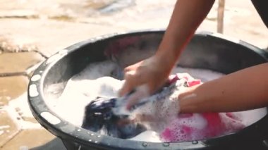 Emaye takımında çamaşır deterjanıyla çamaşır yıkayan kadınlar. Ev işi ve hijyen kavramları. 