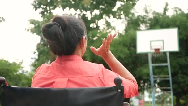 Mujer Joven Sentada Una Silla Ruedas Haciendo Gestos Lanza Una — Vídeo de stock