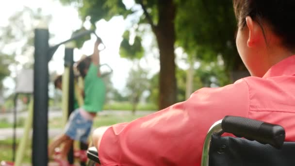 Happy Disabled Woman Sitting Wheelchair Watching Her Daughter Play Exercise — Stock Video