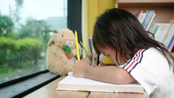 Милая Маленькая Девочка Рисует Цветными Карандашами Газете Дома — стоковое видео