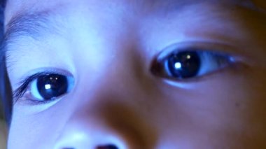 Küçük kızın gece yatağında akıllı telefona bakarken mavi ışığın çocukların gözleri üzerinde olumsuz bir etkisi oluyor..