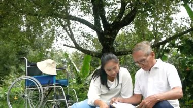 Mutlu engelli büyükbaba parkta torunuyla dinleniyor. Aile mutlu bir yaşam tarzı.