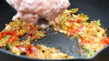 Kızarmış kırmızı biber ve sarımsağı kızartılmış tavada kızartılmış domuz etiyle pişiren bir kadının ellerini yakın. Lezzetli Tayland yemekleri. Basil Yapraklarıyla Kızarmış Domuz Etini Karıştır.