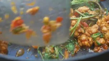 Kızarmış kıymalı domuz kızartması, biberli kızartma tavası, istiridye sosu, mutfaktaki gazdan çıkan sıcak şeker ve kırmızı biberli patates kızartması yapan kadınların yakın çekimi. Lezzetli Tayland yemekleri..