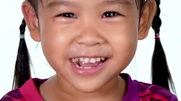 かわいい女の子が甘いドーナツを食べ 白い背景の上に味を楽しむのクローズアップビュー — ストック動画