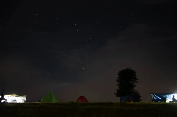 劇的な夜空の下で山の中のテントと星空の夜の山の風景 — ストック写真
