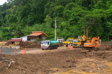 Kırsal bölgedeki sel hasarı sonrasında yol ve altyapıyı tamir eden inşaat araçları