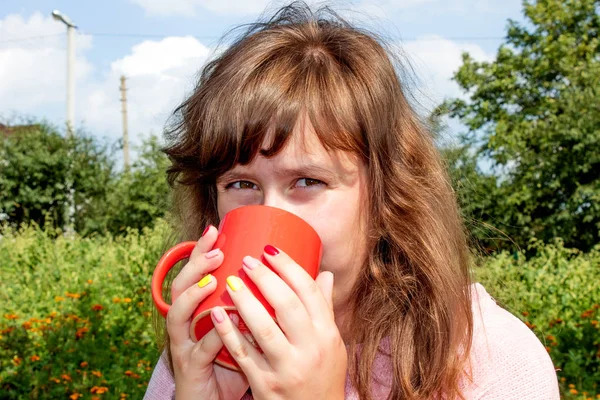 Young girl drinking coffee in nature