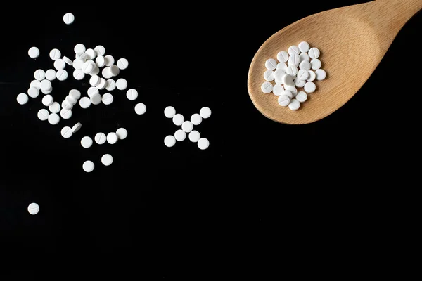 Medication bottle and white pills spilled on blue pastel coloured background. Medication and prescription pills flat lay background. Opioid epidemic.