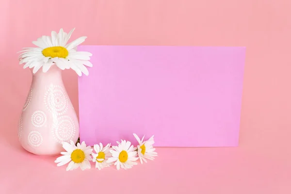 Soft pink light bathroom decor for advertising, design, cover. Cosmetic set on light dressing table. Beautiful flowers in a vase on a pink wall background, mirror on a wooden shelf. mock up