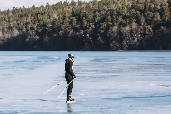 Genç kadın bir doğal göl donmuş buz pateni. Güzel kış günü.