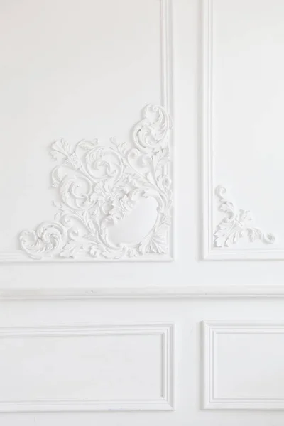 Beautiful ornate white decorative plaster mouldings in studio. The white wall is decorated with exquisite elements of plaster stucco — Stock Photo, Image