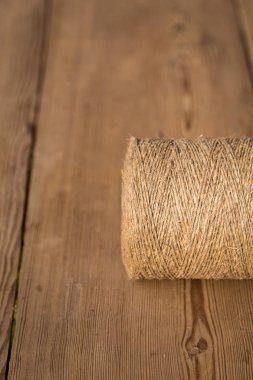 Ahşap arka planda bir sicim rulosu. Seçici odaklanma. Yakın plan. Metin için boş alan.