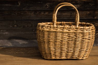 Ahşap bir arka planda antik hasır sepet. Seçici odaklanma. Metin için boş alan