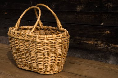 Ahşap bir arka planda antik hasır sepet. Seçici odaklanma. Metin için boş alan.