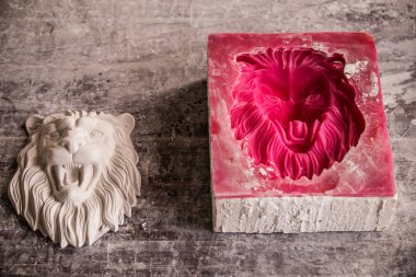 Plaster workshop. Separates the silicone mold from the plaster sculpture of the lions head. clipart