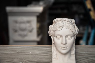 Bir yüz ile alçı yapılmış dekoratif eleman. Atölyede kalıpların oluşturulması. Seçici odaklama.