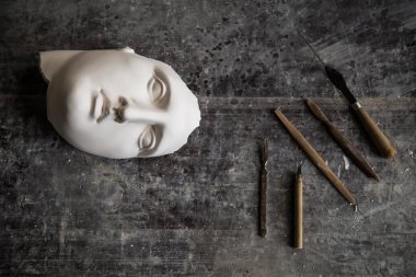 Masadaki heykeltıraşın aletleri. Apollos'un yüzü. Yukarıdan manzara. Metin için boş alan.