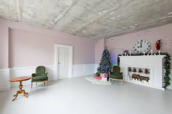 Elegante interior de Navidad con un sillón vintage, chimenea y una mesa . — Foto de Stock