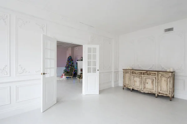Lujoso interior brillante con paredes de estuco, cómoda vintage y árbol de Navidad . — Foto de Stock