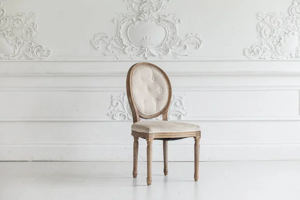 Living room in antique style. Vintage chair against the wall with a bas-relief of plaster stucco. Selective focus. — Stock Photo, Image