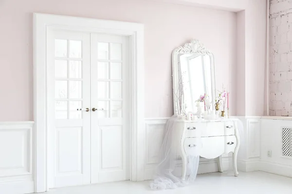 Royal bedroom. Place for make-up girls. Elegant white dressing table with mirror in light classic luxury interior.