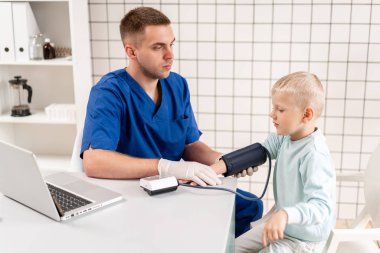 Doktor küçük bir çocuğun kan basıncını ölçtü. Teşhis, sağlık, tıbbi hizmet. Doktor çocuk doktoru kavramı