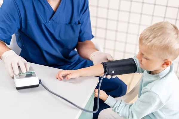 Doktor měří krevní tlak malého chlapce. Diagnostika, zdravotní péče, lékařská služba. Doktorský pediatr — Stock fotografie