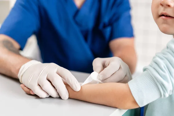 Medische patch. Doctor verbonden een jongen hand met trauma in zijn arm. Elastische verbonden om zijn hand — Stockfoto