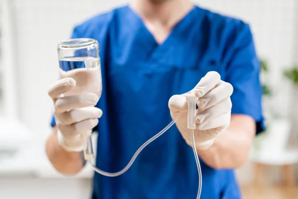 Tıbbi tedavi acil kavramı. Doktor mavi üniformalı, damla iv ve infüzyon pompası tutuyor. Hastanede acil serviste ciddi hasta için intravenöz sıvı.