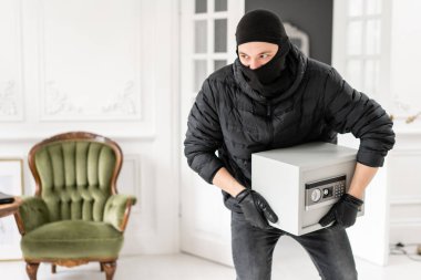 Hırsız, lüks dairede alçı ile bir suç işlemiştir. Siyah Balaclava ile Thief modern elektronik güvenli kutu çalmak.