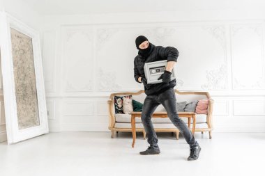 Siyah Balaclava ile Thief modern elektronik güvenli kutu çalmak. Hırsız lüks dairede alçı ile bir suç tamamlar.