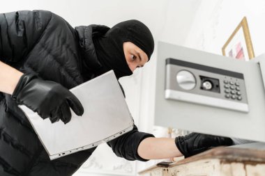 Hırsız elektronik kasayı açar. Hırsız sıva ile lüks dairede bir suç işler. Siyah balaclava ile hırsız güvenli kutu çalmak.