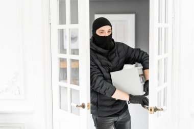 Hırsız, lüks dairede alçı ile bir suç işlemiştir. Siyah Balaclava ile Thief modern elektronik güvenli kutu çalmak.