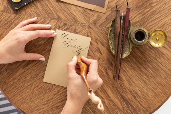 서예가가 잉크로 펜을 들고 있습니다. 소녀는 손으로 쓴 글꼴로 편지를 씁니다. 예술가의 창조적 인 워크샵. 소프트 포커스. — 스톡 사진