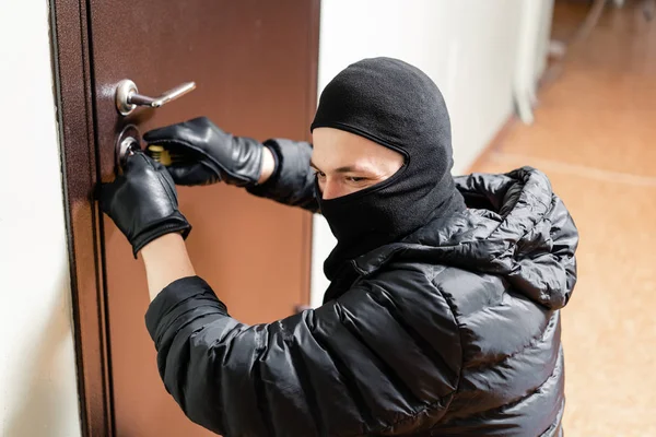 Ladrón que entra en la puerta principal del apartamento después de abrir con éxito la cerradura . —  Fotos de Stock