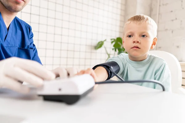 Kleine jongen bezoekende arts in het ziekenhuis. Meten van de bloeddruk en pols controleren — Stockfoto