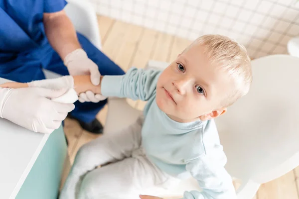 Doktor oblěl chlapce v ruce s traumatem. Elastický oblý kolem ruky — Stock fotografie