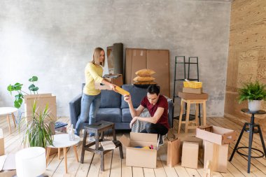 Mutlu gülümseyen çift yeni bir evde hareket ve karton kutuları, tehcir ve yenileme kavramı unpacking