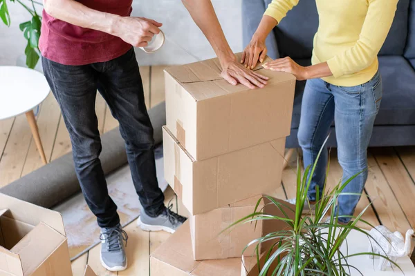 Nahaufnahme von Hand Verpackung Karton, Konzept Umzug Haus. junges Paar zieht gemeinsam in eine neue Wohnung. Umzugskonzept — Stockfoto