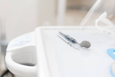 Diş hekimi araç sondası ve ayna. . Diş hekimi kliniğinde stomatological alet. Klinikte diş işleri. Diş hekiminin muayene yaptığı ve sonuçlandırdığı ofis.